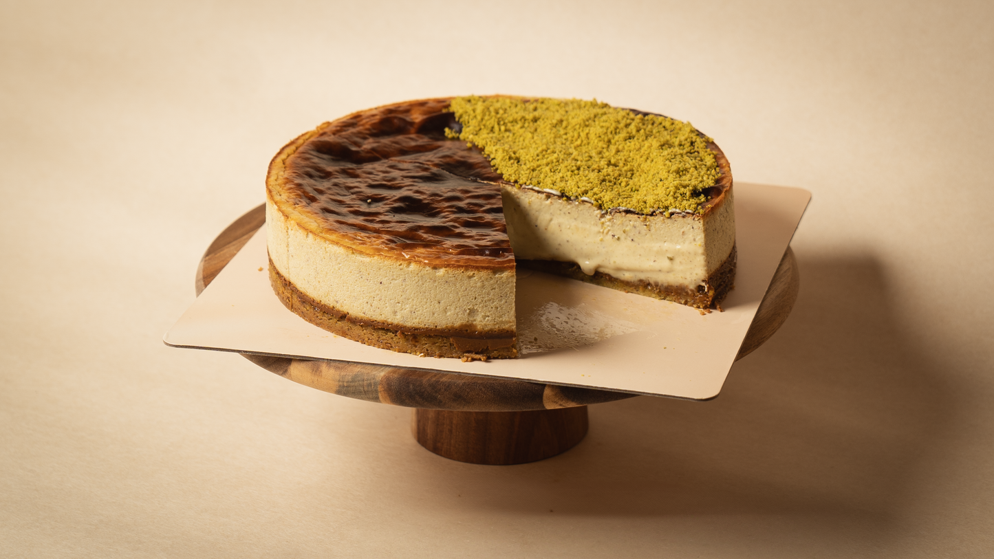Creamy Basque Pistachio Royale cheesecake slice from BasK, showing caramelized top and molten texture, with pistachio cream and praline layers
